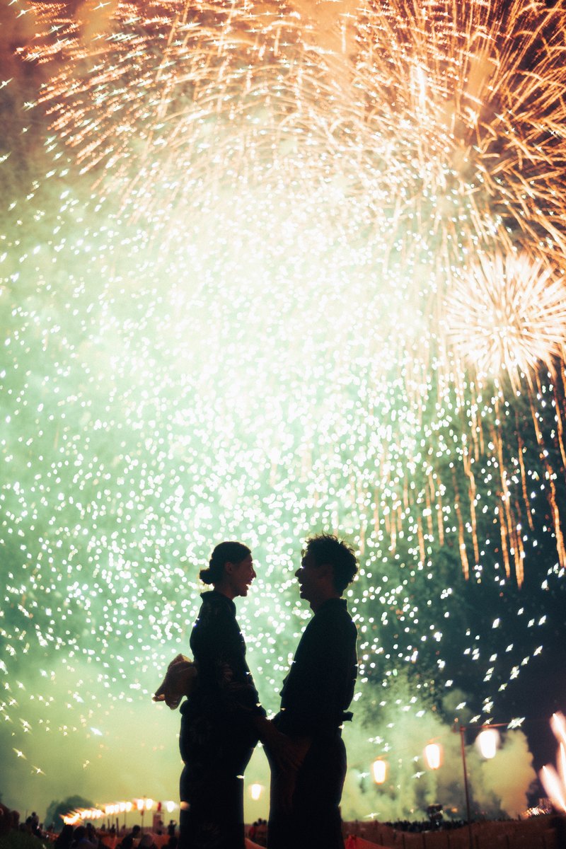 A couple silhouetted against summer fireworks